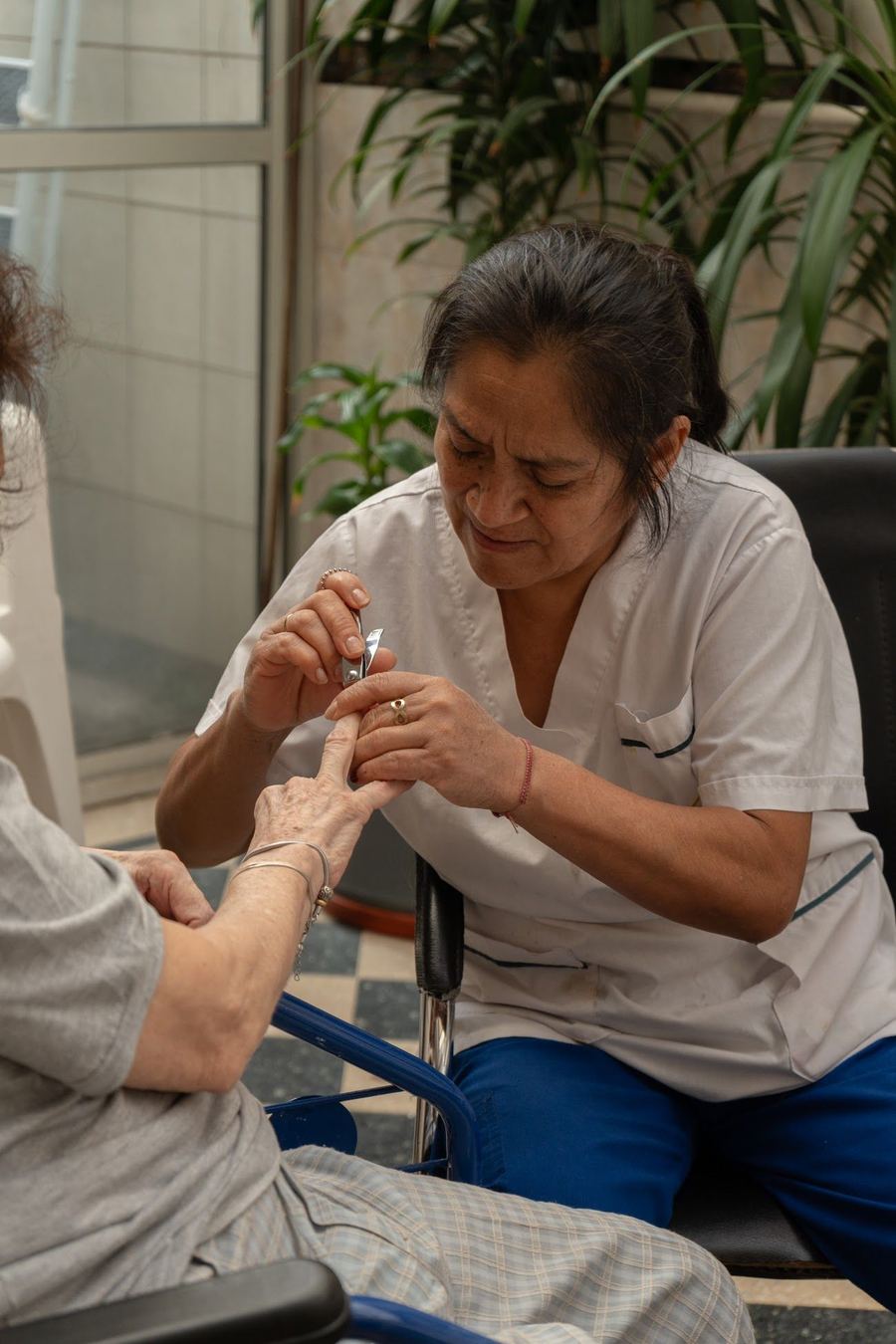 Una enfermera atiende con cuidado la mano de una residente